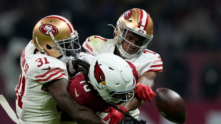 Arizona Cardinals wide receiver DeAndre Hopkins, center, loses control of the ball as he is hit by San Francisco 49ers cornerback Charvarius Ward, right, and safety Tashaun Gipson Sr. during the second half of an NFL football game Monday, Nov. 21, 2022, in Mexico City. (AP Photo/Fernando Llano)