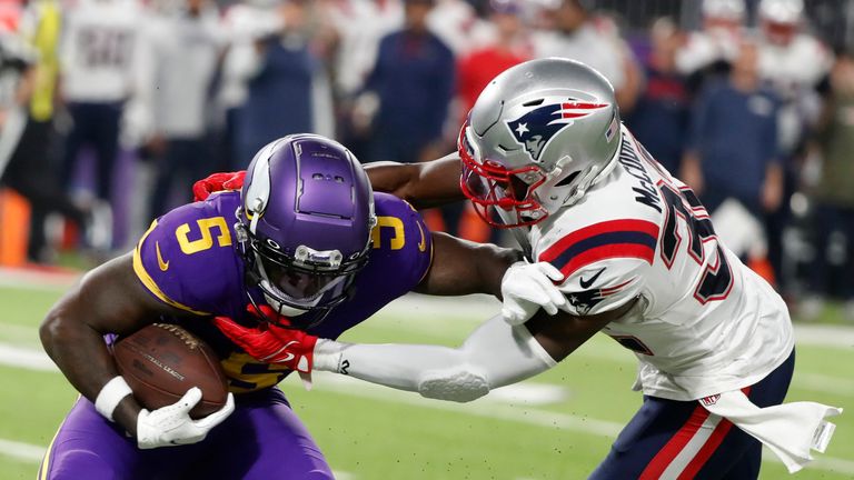 Minnesota Vikings wide receiver Jalen Reagor (5) tries to break a tackle by New England Patriots safety Devin McCourty, right, after catching a pass during the second half of an NFL football game, Thursday, Nov. 24, 2022, in Minneapolis. (AP Photo/Bruce Kluckhohn)


