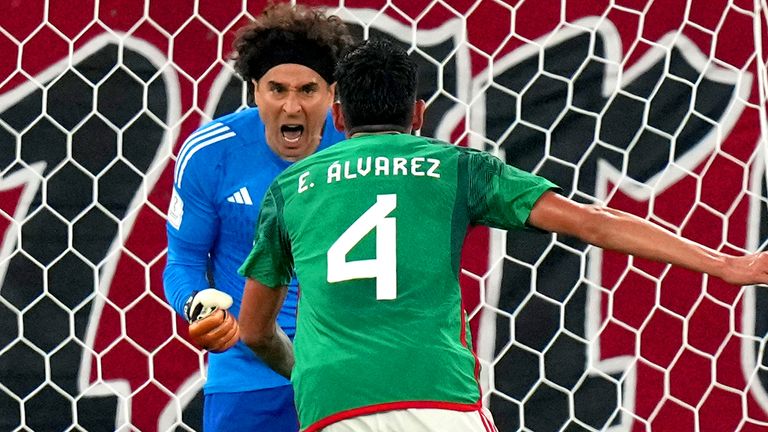 Guillermo Ochoa celebrates with team-mate Edson Alvarez after saving Robert Lewandowski&#39;s penalty