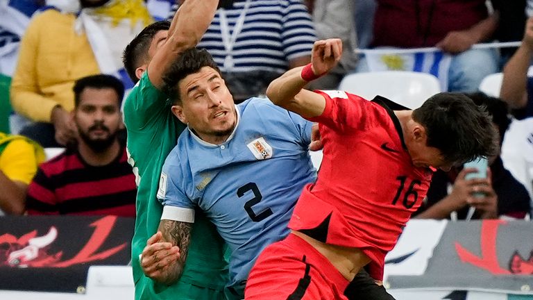 Uruguay&#39;s goalkeeper Sergio Rochet punches clear under pressure from Hwang Ui-jo