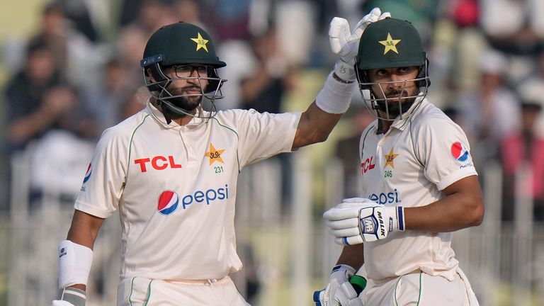 Pakistan's Abdullah Shafique, right, is congratulated by teammate Imam-ul-Haq after scoring fifty during the second day of the first test cricket match between Pakistan and England, in Rawalpindi, Pakistan, Friday, Dec. 2, 2022. (AP Photo/Anjum Naveed)