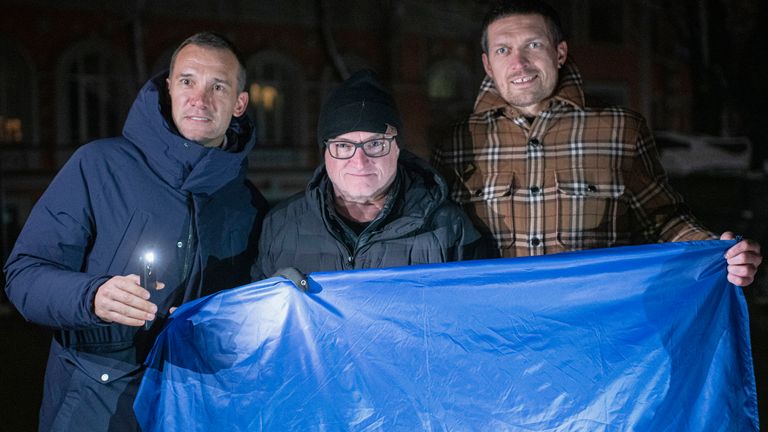 Ambassadors of UNITED24 fundraising platform former striker and coach of the Ukraine national soccer team Andriy Shevchenko, left, retired American astronaut Scott Kelly, centre, Ukrainian boxing heavyweight champion Oleksandr Usyk, right, pose with the Ukrainian flag in the city center in Kyiv, Ukraine, Monday, Nov. 28, 2022. Six ambassadors of UNITED24 fundraising platform, Andriy Shevchenko, Oleksandr Usyk, Scott Kelly among them, simultaneously announced a joint charity campaign have teamed up to raise funds for generators that will be used to power Ukrainian hospitals. (AP Photo/Andrew Kravchenko)