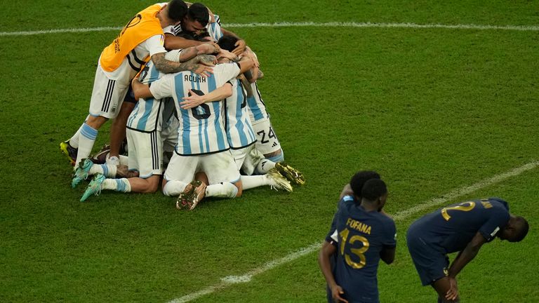 Οι παίκτες της Αργεντινής πανηγυρίζουν τη νίκη τους στο Παγκόσμιο Κύπελλο στα πέναλτι, καθώς οι παίκτες της Γαλλίας στέκονται απογοητευμένοι