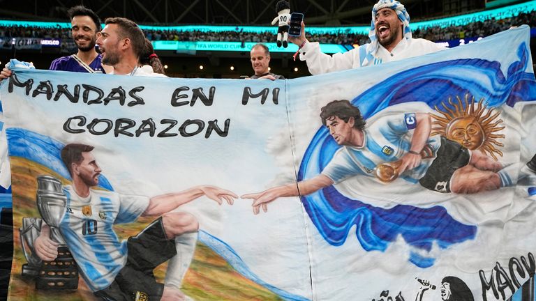 Argentina hold up a banner in tribute to Lionel Messi and Diego Maradona