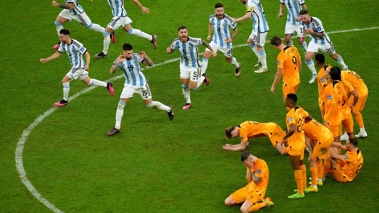Argentina's players celebrate their victory in the penalty shootout in front of the Dutch players