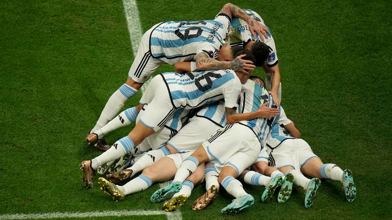 Argentina players celebrate with teammate Lionel Messi who scored his side's opening goal during the World Cup final soccer match between Argentina and France at the Lusail Stadium in Lusail, Qatar, Sunday, Dec. 18, 2022. (AP Photo/Francisco Seco)