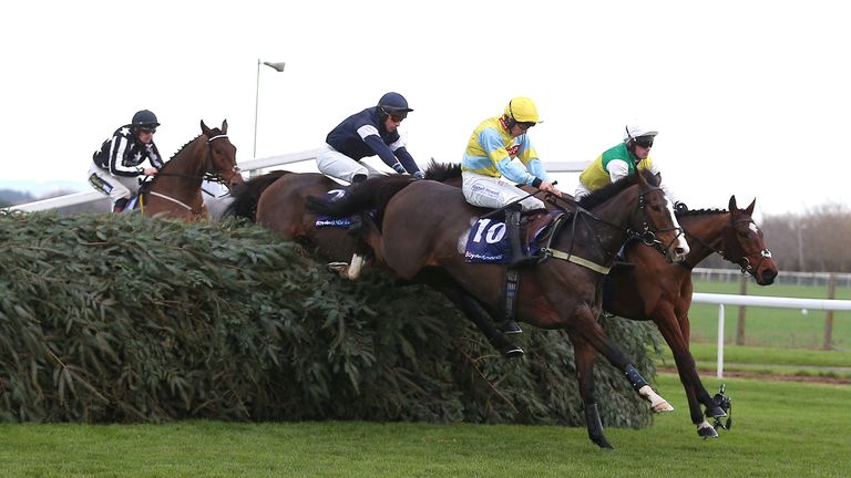 Ashtown Lad (black cap) clears one of the National fences at Aintree