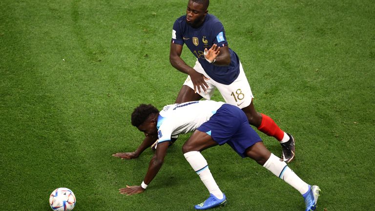 Bukayo Saka appears to be fouled by France's Dayot Upamecano