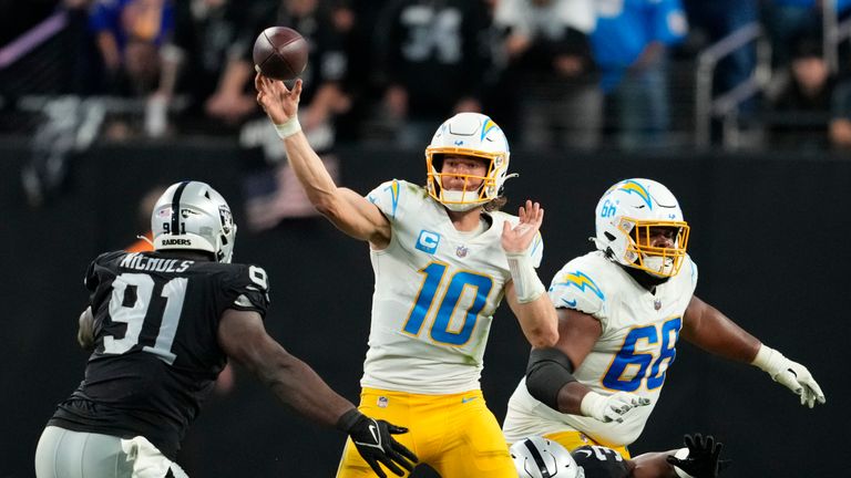 Los Angeles Chargers quarterback Justin Herbert (10) passes under pressure from Las Vegas Raiders defensive tackle Bilal Nichols (91) during the second half of an NFL football game, Sunday, Dec. 4, 2022, in Las Vegas. The Raiders won 27-20.