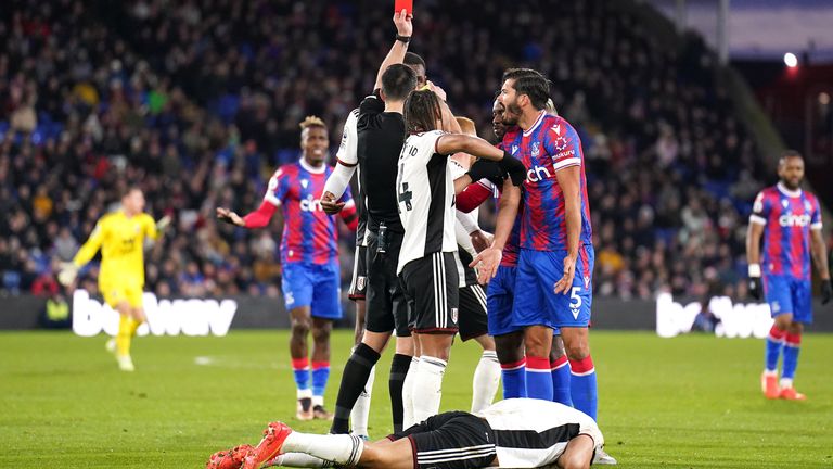 Referee Andrew Madley shows a red card to James Tomkins