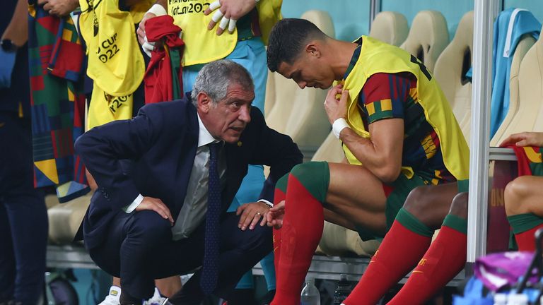 06 December 2022, Qatar, Lusail: Soccer, Qatar 2022 World Cup, Portugal - Switzerland, Round of 16, at Lusail Stadium, Portugal coach Fernando Santos talks to Portugal's Cristiano Ronaldo, who is about to be substituted. 