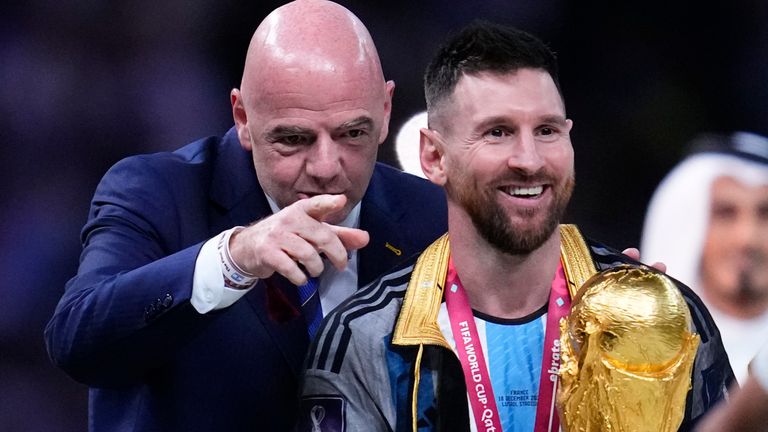 Argentina&#39;s Lionel Messi walks towards his teammates after receiving from FIFA President Gianni Infantino the trophy after Argentina defeated France in the World Cup final soccer match at the Lusail Stadium in Lusail, Qatar, Sunday, Dec. 18, 2022. (AP Photo/Natacha Pisarenko)