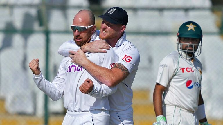 England's Jack Leach, left, celebrates with teammate Ben Stokes, center, after taking the wicket of Pakistan's Abdullah Shafique during the third day of third test cricket match between England and Pakistan