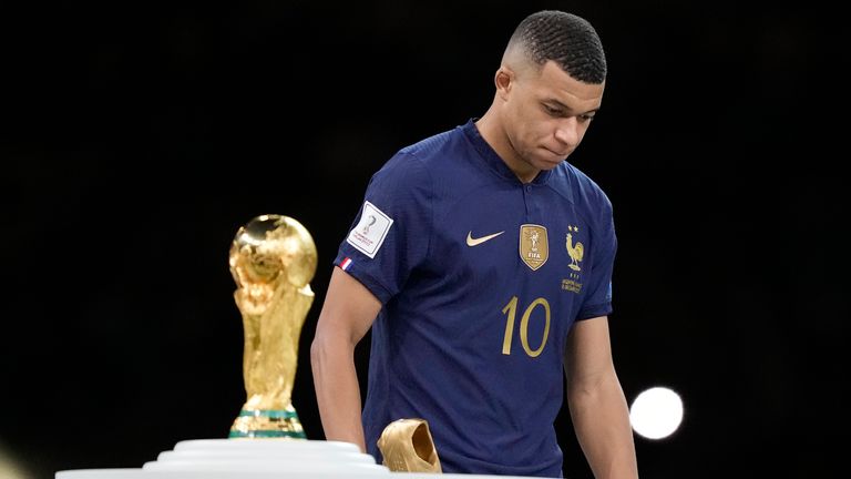 Kylian Mbappe walks past the World Cup trophy following France's loss