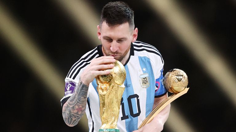 Lionel Messi kisses the World Cup trophy after winning the Golden Ball award