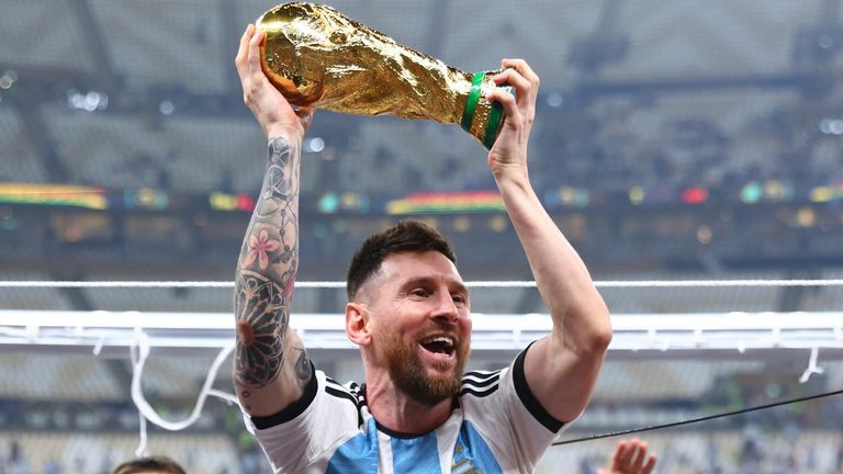 Lionel Messi holds the World Cup trophy aloft