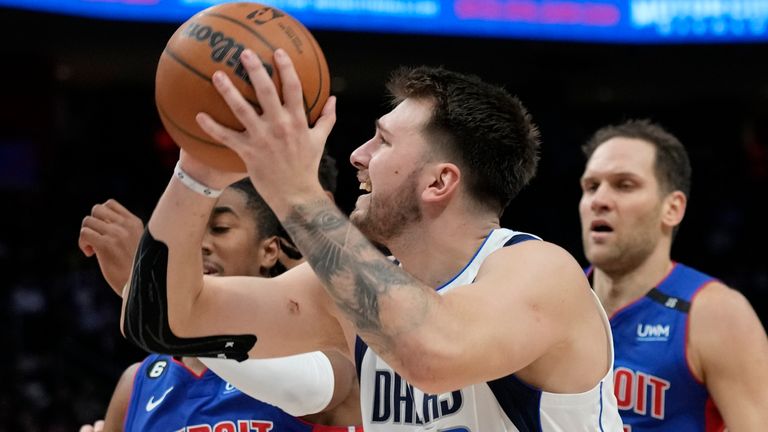 Dallas Mavericks guard Luka Doncic (77) is defended b Detroit Pistons guard Jaden Ivey (23) during the second half of an NBA basketball game, Thursday, Dec. 1, 2022, in Detroit. (AP Photo/Carlos Osorio)