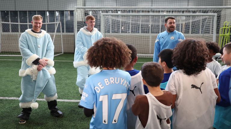 Kevin De Bruyne and Cole Palmer donned Santa suits to surprise children during a coaching session at Manchester City&#39;s training ground.