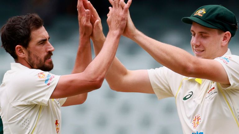 Australia&#39;s Mitchell Starc, left, celebrates with teammate Cameron Green after taking the wicket of the West Indies&#39; Devon Thomas on the fourth day of their cricket test match in Adelaide, Sunday, Nov. 11, 2022. (AP Photo/James Elsby)
