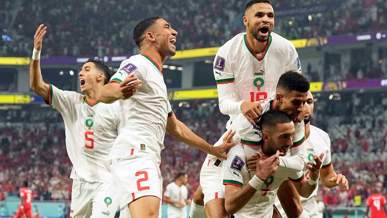 Morocco's Hakim Ziyech (7) celebrates after scoring his side's opening goal with team mate Azzedine Ounahi, top center, Youssef En-Nesyri, top, Achraf Hakimi (2), Nayef Aguerd (5) and background, and Sofyan Amrabat, right, during the World Cup group F soccer match between Canada and Morocco at the Al Thumama Stadium in Doha , Qatar, Thursday, Dec. 1, 2022. (AP Photo/Pavel Golovkin)