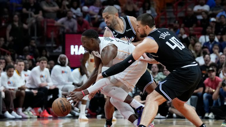 Miami Heat center Bam Adebayo, center, keeps the ball away from Los Angeles Clippers center Ivica Zubac (40) and forward Nicolas Batum, rear, during the second half of an NBA basketball game, Thursday, Dec. 8, 2022, in Miami. 