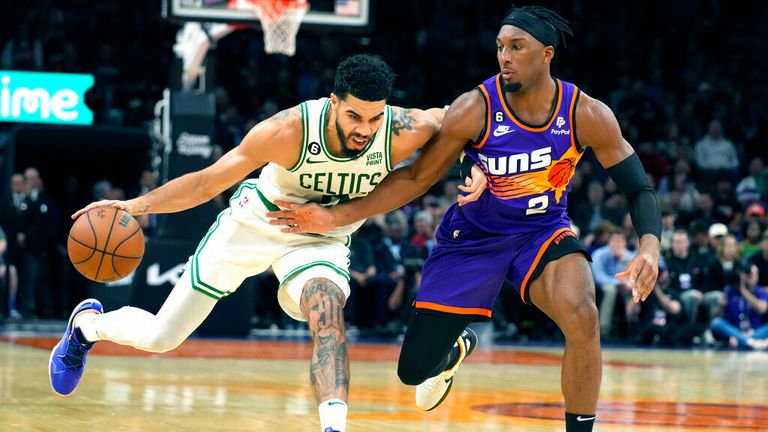Boston Celtics forward Jayson Tatum (0) drives at Phoenix Suns forward Josh Okogie during the first half of an NBA basketball game Wednesday, December 7, 2022 in Phoenix.  (AP Photo/Rick Scutteri)