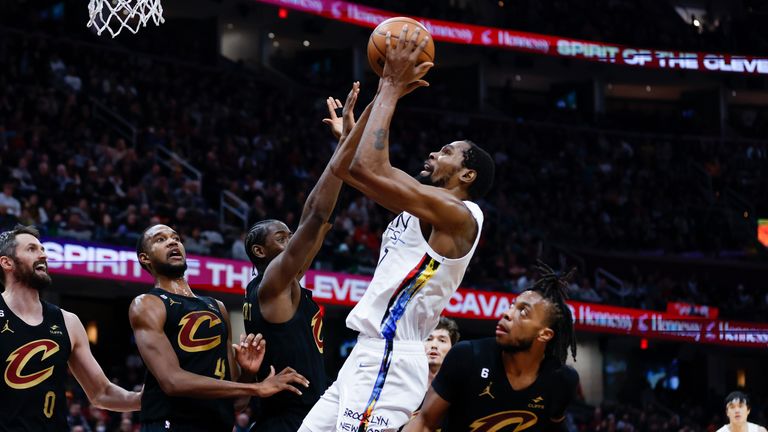 Kevin Durant shoots against Cleveland Cavaliers' Evan Mobley, Caris LeVert and guard Darius Garland.
