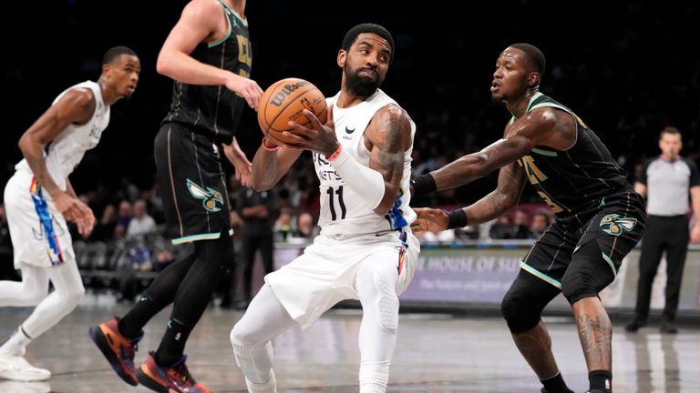 Brooklyn Nets guard Kyrie Irving (11) drives around Charlotte Hornets guard Terry Rozier (3) during the second half of an NBA basketball game, Wednesday, Dec. 7, 2022, in New York. (AP Photo/John Minchillo)



