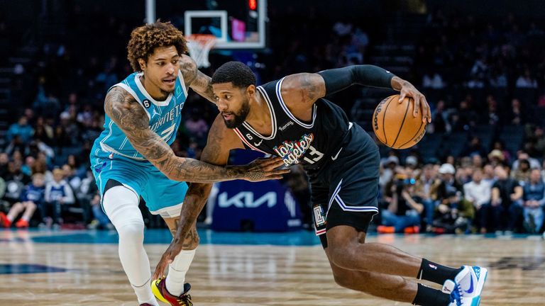 Charlotte Hornets guard Kelly Oubre Jr. guards LA Clippers guard Paul George (13) as he drives with the ball during the first half of an NBA basketball game on Monday, Dec. 5, 2022, in Charlotte, N.C. (AP Photo/Scott Kinser)