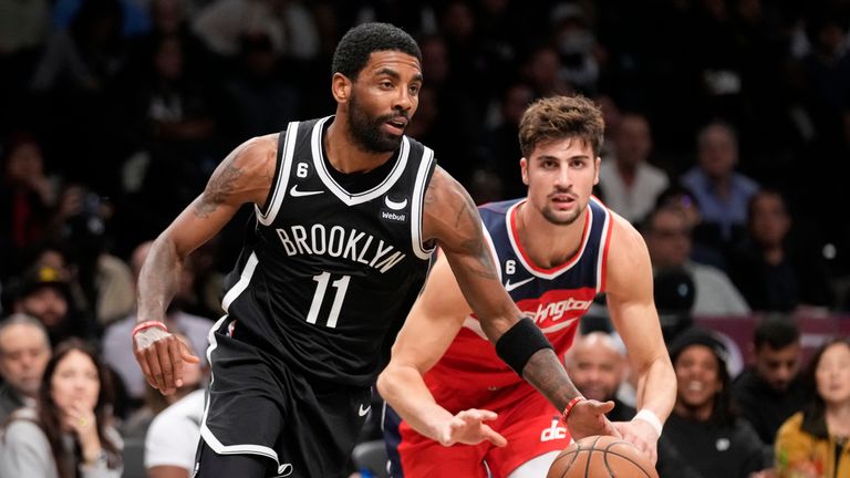 Brooklyn Nets guard Kyrie Irving (11) dribbles past Washington Wizards forward Deni Avdija, right, during the second half of an NBA basketball game, Wednesday, Nov. 30, 2022, in New York.