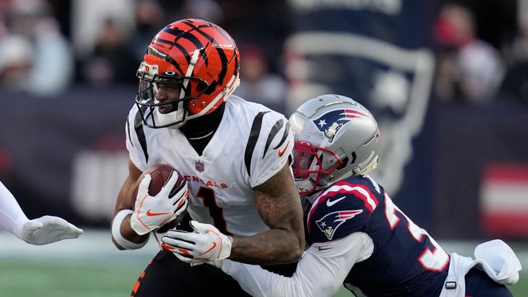 Cincinnati Bengals wide receiver Ja&#39;Marr Chase (1) is brought down by New England Patriots cornerback Jonathan Jones (31) during the second half of an NFL football game, Saturday, Dec. 24, 2022, in Foxborough, Mass.