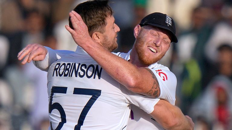 England's Ollie Robinson, left, celebrates with Ben Stokes after taking the wicket of Pakistan Abdullah Shafique during the fourth day of the first test cricket match between Pakistan and England, in Rawalpindi, Pakistan, Sunday, Dec. 4, 2022. (AP Photo/Anjum Naveed)