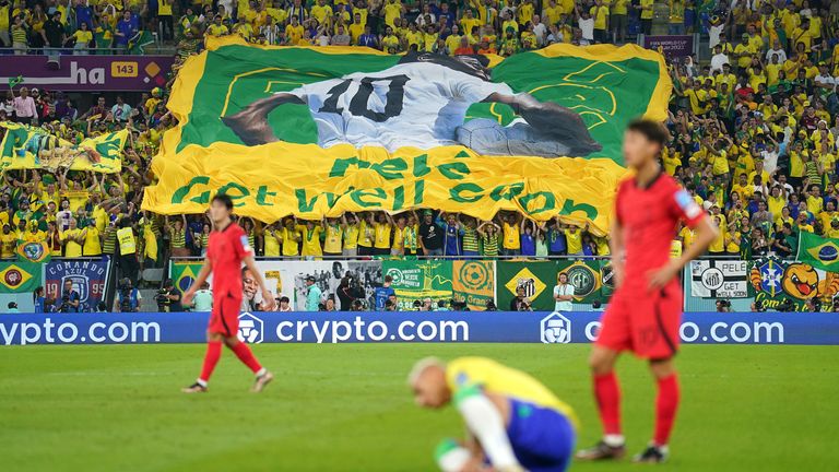 Fans display a banner with a message that reads 'Get Well Soon' for Brazil legend Pele
