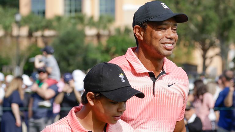 Tiger Woods and his son Charlie Woods walk down the fairway of the first hole during the first round of the PNC Championship golf tournament Saturday, Dec. 17, 2022, in Orlando, Fla. (AP Photo/Kevin Kolczynski)