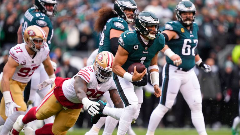Philadelphia Eagles quarterback Jalen Hurts (1) runs with the ball as San Francisco 49ers defensive tackle Javon Kinlaw (99) tries to stop him during the first half of the NFC Championship NFL football game between the Philadelphia Eagles and the San Francisco 49ers on Sunday, Jan. 29, 2023, in Philadelphia. 
