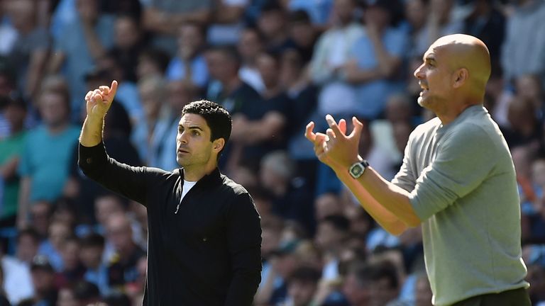 Arsenal&#39;s manager Mikel Arteta, left, and Manchester City&#39;s head coach Pep Guardiola gesture during the English Premier League soccer match between Manchester City and Arsenal at Etihad stadium in Manchester, England, Saturday, Aug. 28, 2021.