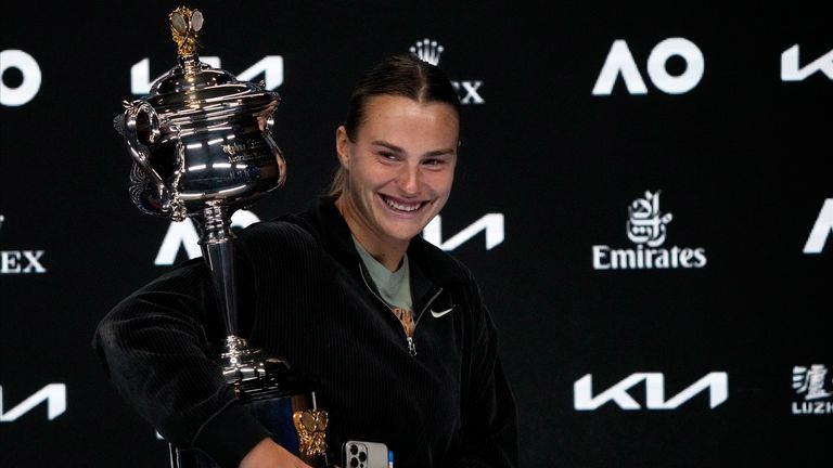 Aryna Sabalenka of Belarus carries the Daphne Akhurst Memorial Trophy as she leaves her press conference after defeating Elena Rybakina of Kazakhstan in the women&#39;s singles final at the Australian Open tennis championship in Melbourne, Australia, Saturday, Jan. 28, 2023. (AP Photo/Dita Alangkara)