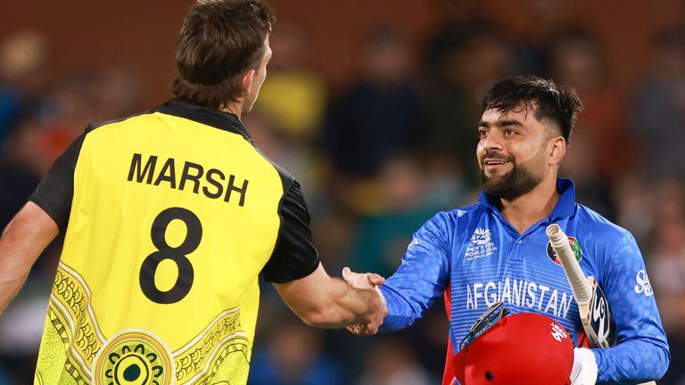 Mitchell Marsh dari Australia, kiri, berjabat tangan dengan Rashid Khan dari Afghanistan setelah pertandingan kriket Piala Dunia T20 antara Australia dan Afghanistan di Adelaide, Australia, Jumat, 4 November 2022. (AP Photo/James Elsby )