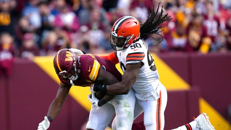 Cleveland Browns defensive end Jadeveon Clowney (90) tackles Washington Commanders running back Brian Robinson Jr. (8) during the second half of an NFL football game, Sunday, Jan. 1, 2023, in Landover, Md. (AP Photo/Susan Walsh)