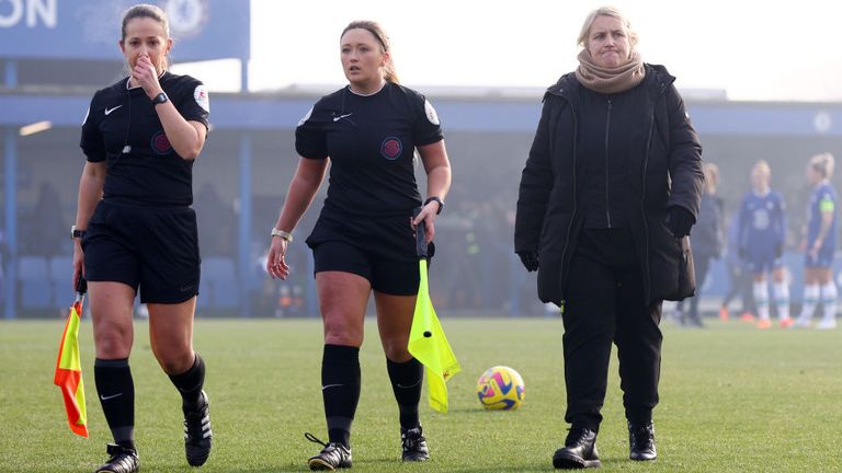 Chelsea manager Emma Hayes leaves the pitch with the match officials after the postponement. 
