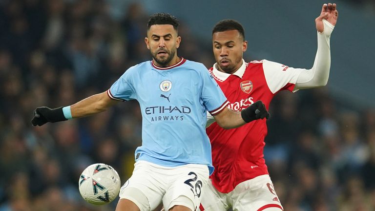 Manchester City&#39;s Riyad Mahrez, left, challenges for the ball with Arsenal&#39;s Gabriel during the English FA Cup 4th round soccer match between Manchester City and Arsenal at the Etihad Stadium in Manchester, England, Friday, Jan. 27, 2023. (AP Photo/Dave Thompson)