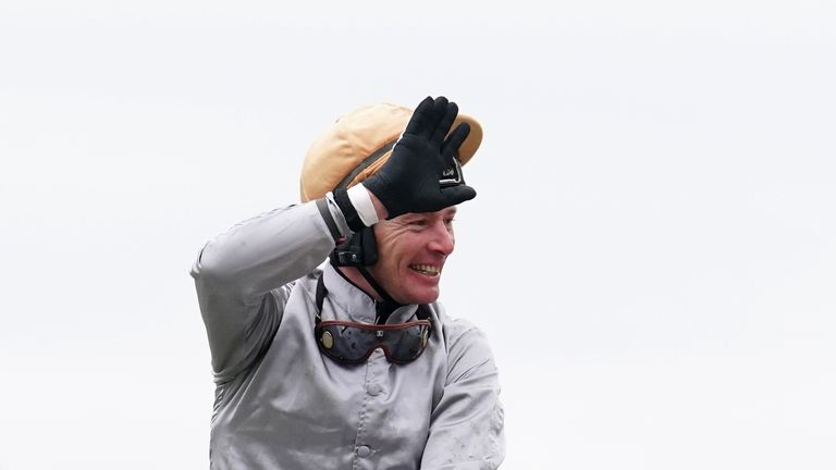 Jockey Johnny Charron wavs to the crowd at Cheltenham as Gold Tweet is led back in