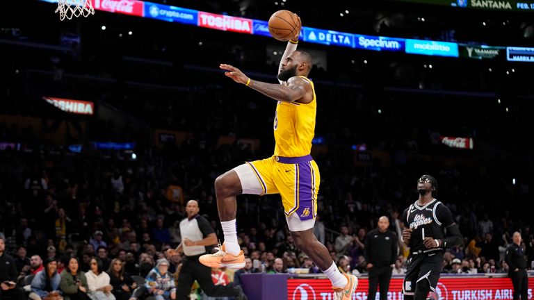 Los Angeles Lakers forward LeBron James, left, dunks as Los Angeles Clippers guard Reggie Jackson watches during the second half of an NBA basketball game Tuesday, Jan. 24, 2023, in Los Angeles. 