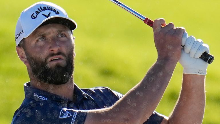 Jon Rahm, of Spain, watches after hitting out of a bunker on the 17th hole of the South Course at Torrey Pines during the third round of the Farmers Insurance Open golf tournament, Friday, Jan. 27, 2023, in San Diego. (AP Photo/Gregory Bull)