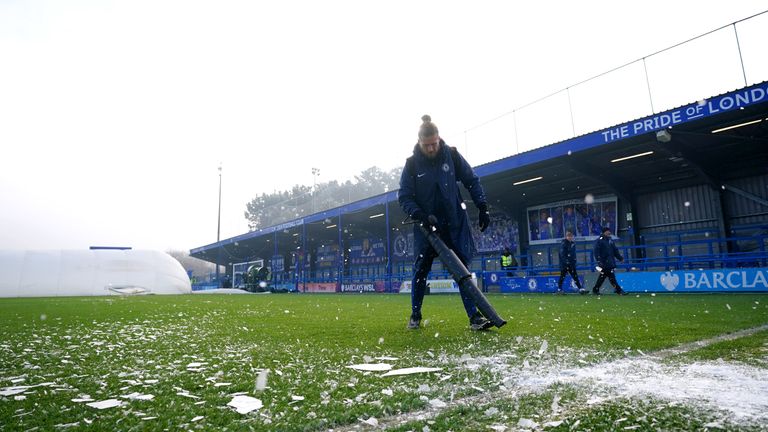 Groundstaff di Kingsmeadow mencoba menghilangkan es dari lapangan sebelum pertandingan WSL antara Chelsea dan Liverpool