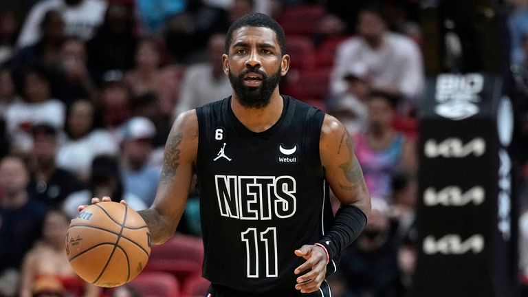 Brooklyn Nets guard Kyrie Irving takes the ball downcourt during the first half of an NBA basketball game against the Miami Heat. 