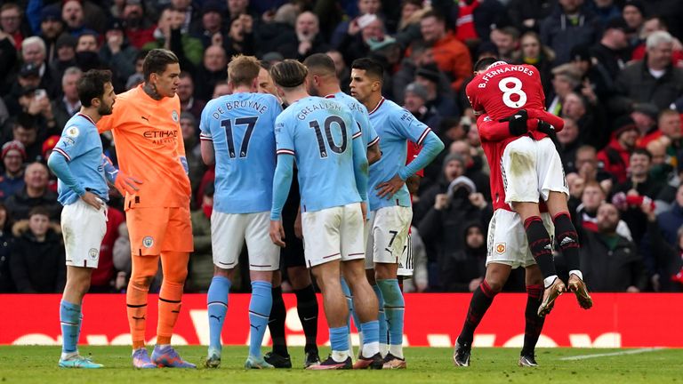 Manchester City players surround referee Stuart Attwell as Bruno Fernandes celebrates his goal