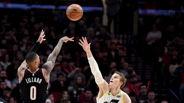 Portland Trail Blazers guard Damian Lillard, left, hits a 3-point shot over Utah Jazz forward Lauri Markkanen during the second half of an NBA basketball game.