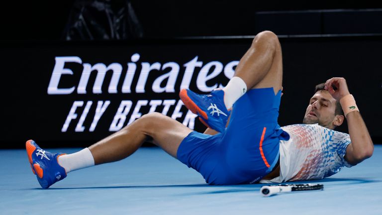 Novak Djokovic of Serbia falls while playing Stefanos Tsitsipas of Greece during the men's singles final at the Australian Open tennis championships in Melbourne, Australia, Sunday, Jan. 29, 2023. (AP Photo/Asanka Brendon Ratnayake)