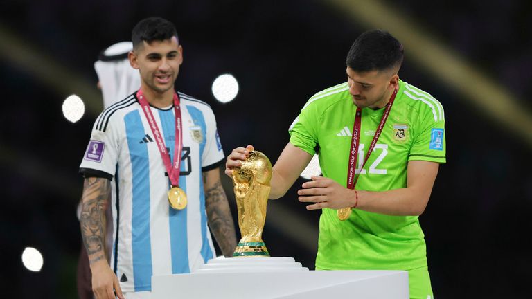 Romero (à gauche) à côté du trophée de la Coupe du monde